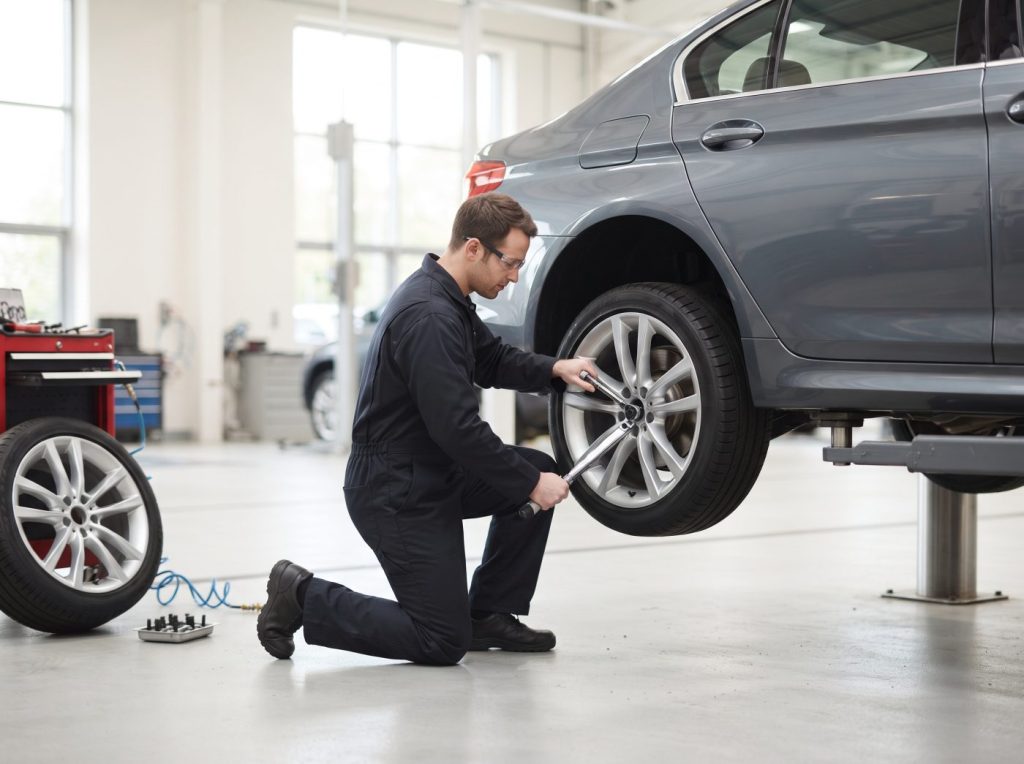 Technician torquing an alloy wheel back onto a car at Top Tyres